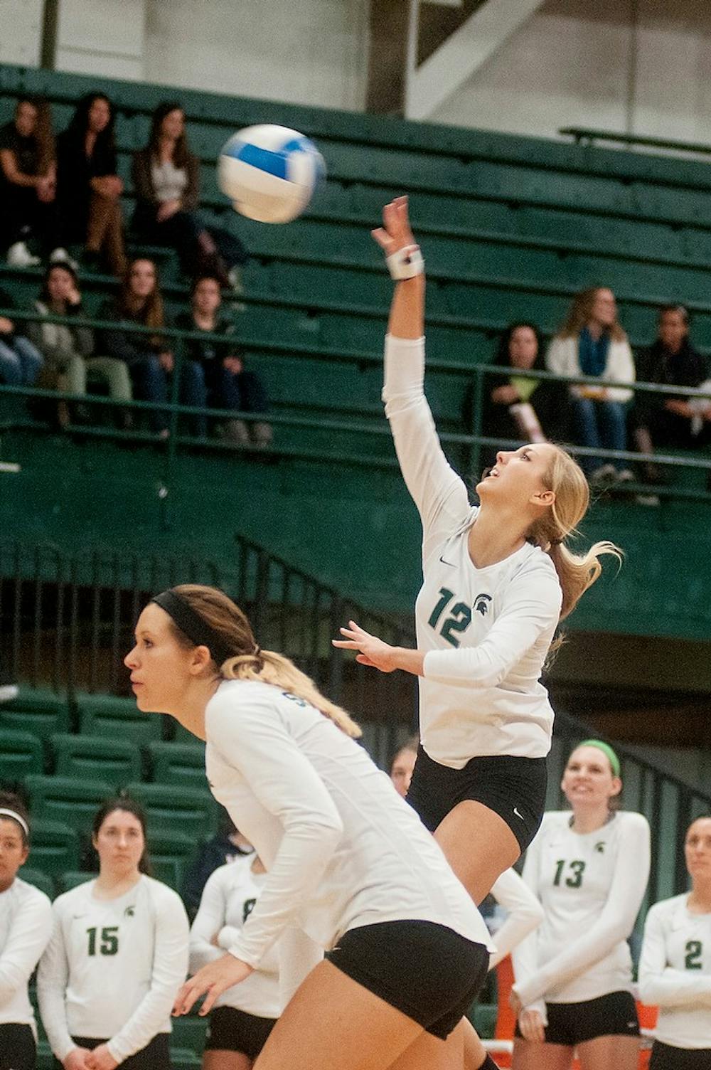 <p>Freshman setter Rachel Minarick spikes the ball while senior outside hitter Taylor Galloway holds her position for the return Nov. 15, 2014, during the game against Indiana University at Jenison Field House. The Spartans defeated the Hoosiers, 3-0. Raymond Williams/The State News</p>