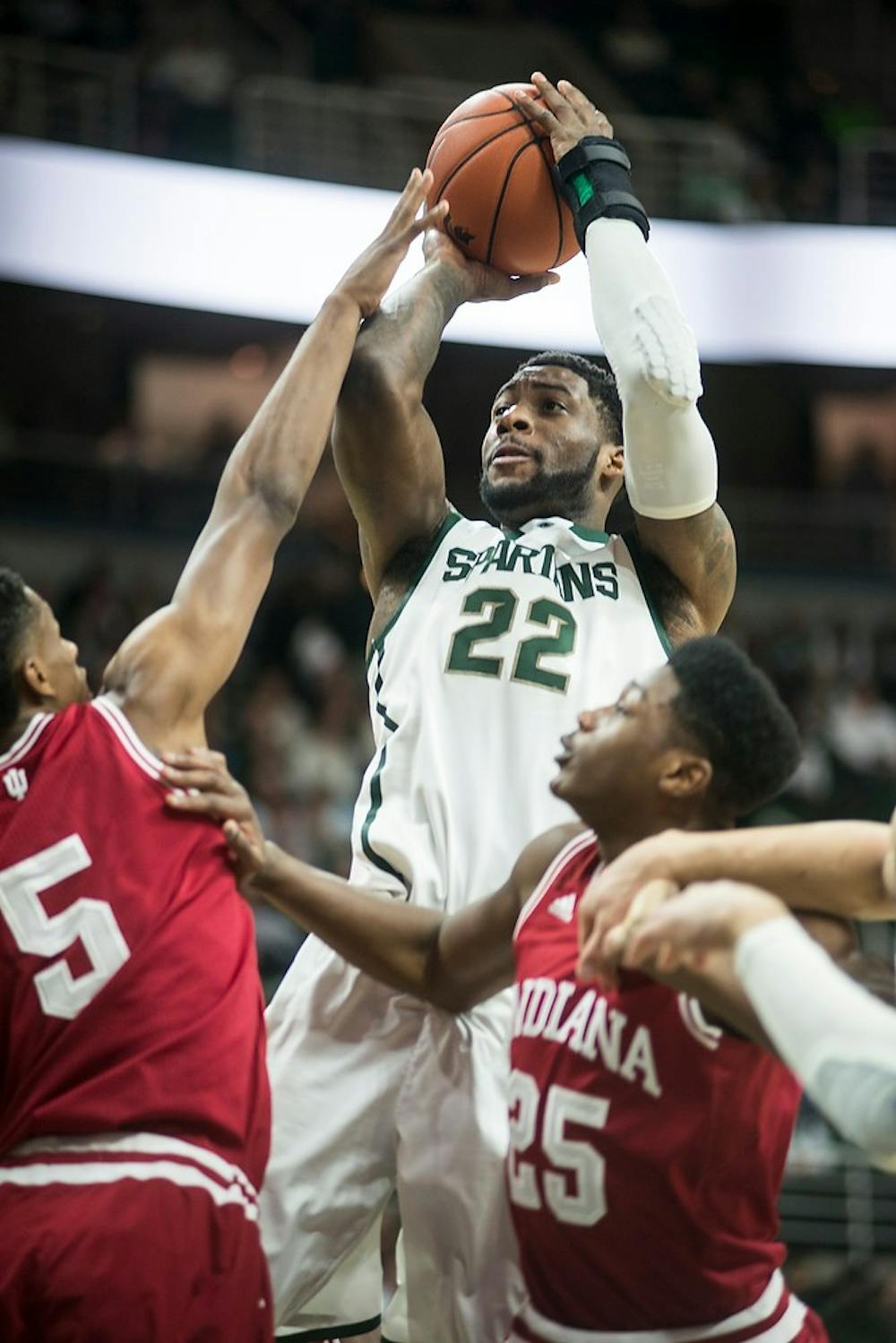 <p>Senior forward/guard Branden Dawson shoots for a basket over Indiana forward Troy Williams and forward Emmitt Holt Jan. 5, 2015, during the game against Indiana at Breslin Center. At halftime, the Spartans were leading the hoosiers, 36-17. Erin Hampton/The State News</p>
