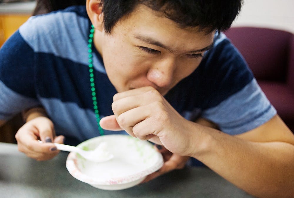 	<p>Packaging sophomore Daniel Jiang tries to clear his throat at the rice-eating competition, Tuesday, Jan. 29, 2013, at Holden Hall during an &#8220;Amazing Race&#8221; organized by the Vietnamese Student Association. Justin Wan/The State News</p>