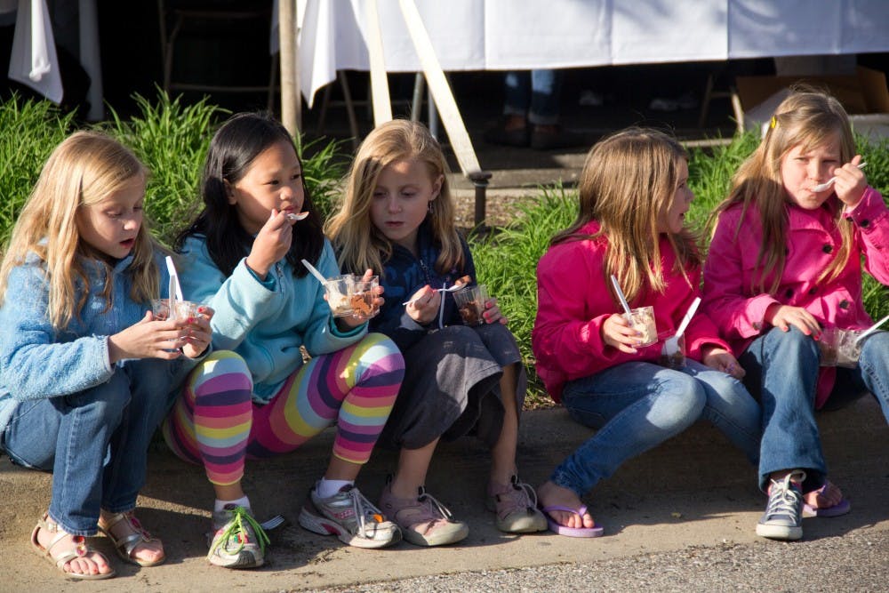 From left, Jillian Draheim, 8, Somer Soderman, 9, Abbie Draheim, 8, Kali Fransisco, 9, and Nina Largey, 8 sit side by side enjoying the foods from the first-ever Taste of East Lansing event hosted by the city of East Lansing's Community Relations Coalition Saturday evening at Ann Street Plaza The event featured local food vendors, games, arts & crafts. Aaron Snyder/The State News 