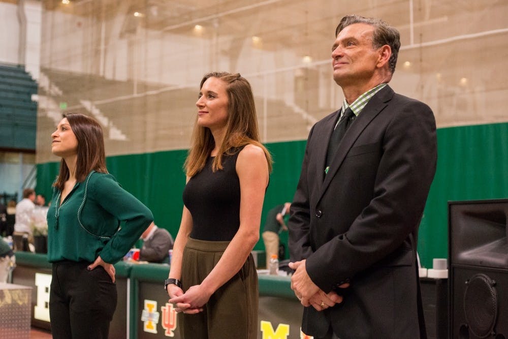 <p>Left, assistant coach Nicole Curler, assistant coach Ashley Noll, and interim head coach Mike Rowe smile during a senior day presentation after the meet against Bowling Green on March 5, 2017 at Jenison Field House. The Spartans defeated Bowling Green, 195.900-193.600.</p>