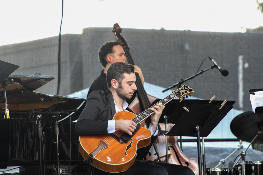 A guitarist strums along with the rest of The Gathering Orchestra at the East Lansing Summer Solstice Jazz Festival on June 21, 2024. 