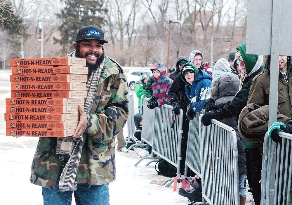 	<p>Former <span class="caps">MSU</span> running back T.J. Duckett delivers pizzas to students waiting in line on Tuesday outside of Breslin Center. Duckett was a Spartan from 1999-2001.  Katie Stiefel/The State News</p>
