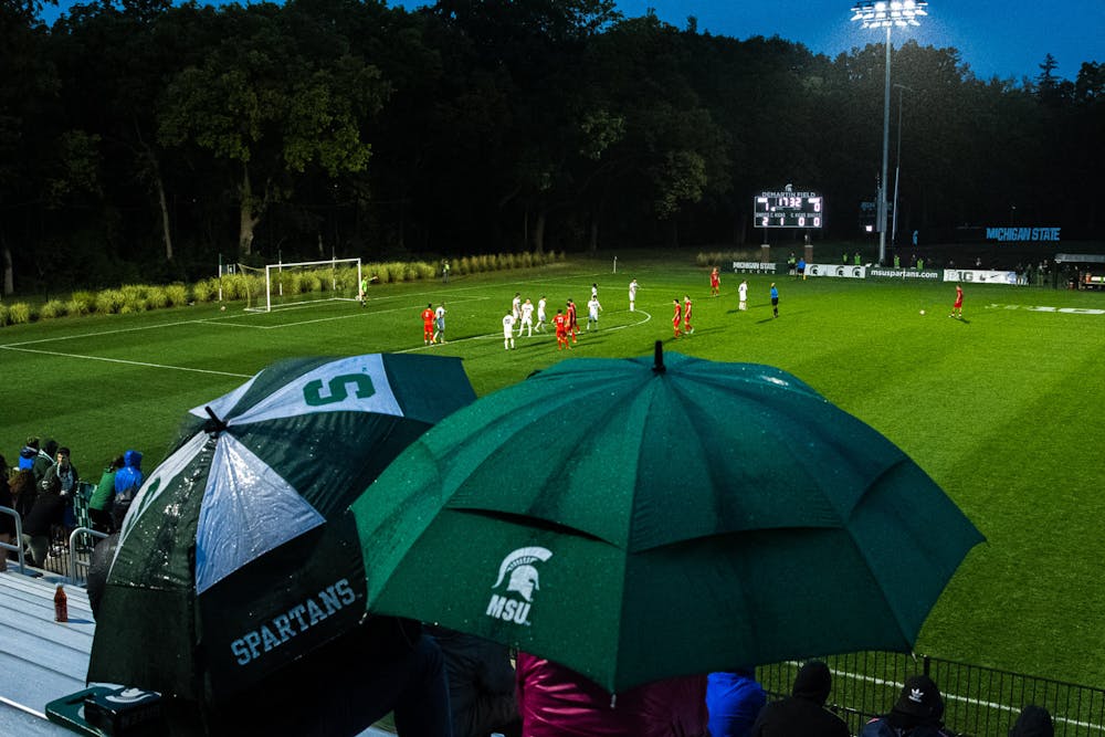 <p>Two fans sit through the rain at DeMartin Stadium. Michigan State men&#x27;s soccer team defeated Duquesne 1-0 on Sept. 11, 2021 in East Lansing.</p>
