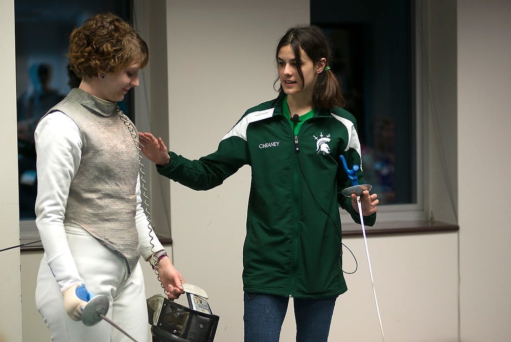 <p>Fencing club president and biochemistry senior Laura Cheaney, right, presents with Women's Foil captain and biology senior Elyse Horack Feb. 25, 2015, about fencing outfits and weapons in the North Conference Room of the MSU Library. Emily Nagle/The State News</p>