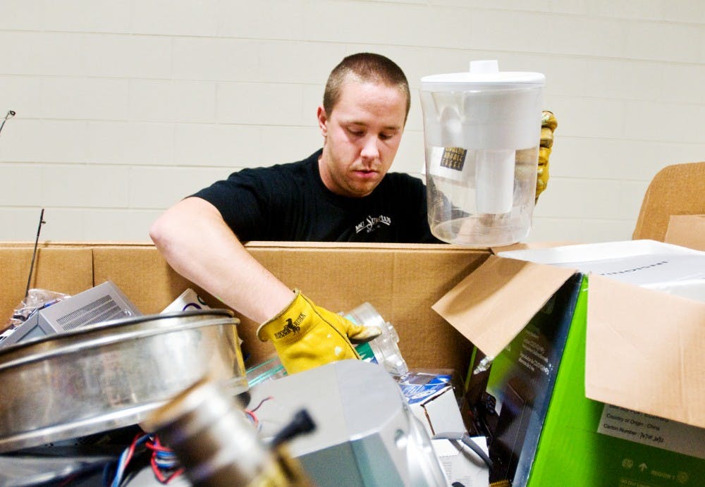 Chris Hampterton, a MSU Surplus Store employee, sorts through a bin of donated objects Tuesday at the store, 223 Surplus and Recycling Center. As part of its biannual Community Reuse Days, the Surplus Store is accepting donations of items to be purchased in the future or recycled. Matt Radick/The State News