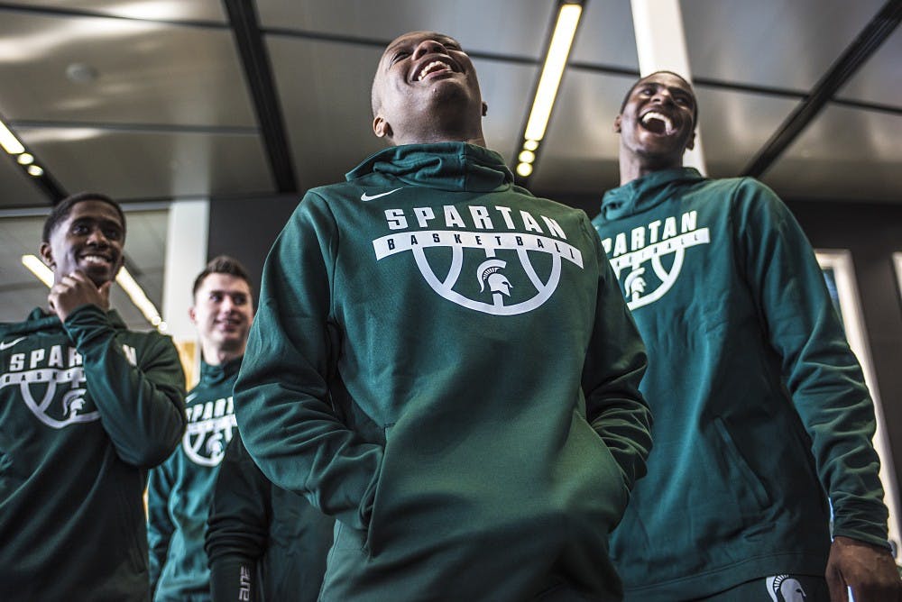 Sophomore guard Cassius Winston (5) laughs with his teammates as they watch videos of themselves at the Tom Izzo Hall of History on Oct. 20, 2017 at the Breslin Center. Attendees included the Board of Trustees, Lou Anna K Simon, Mark Hollis and the Skandalaris family.