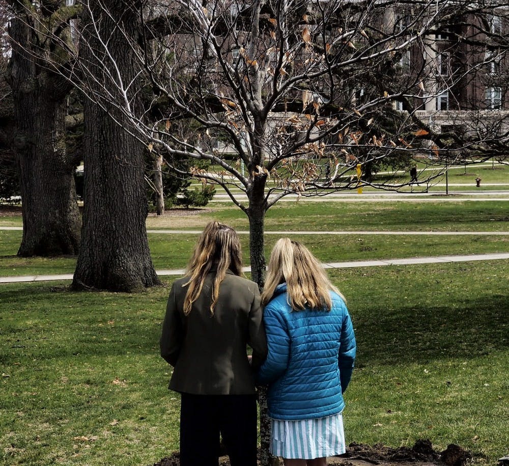     Sister Survivors Amanda Cosman and Mimi Wegener stand in front of the newly planted "Survivor Tree" during the Survivor Tree Dedication Ceremony east of the MSU Museum building on April 16, 2019. The tree planting ceremony is to honor survivors and family's members effected by sexual violence. 