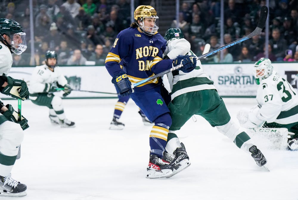 <p>Notre Dame's senior forward Jesse Lansdell (14) clashes with Michigan State's graduate student defender Michael Underwood (22) during a game at Munn Ice Arena on Feb. 3, 2023. The Spartans defeated the Fighting Irish 3-0.</p>