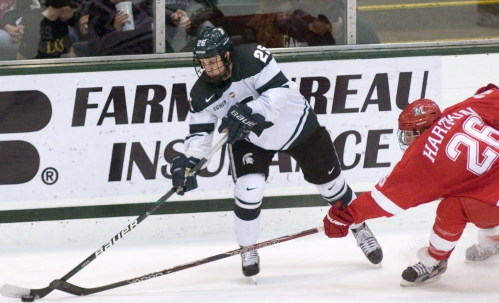 Freshman forward Brent Darnell makes a pass past Redhawk defense Joe Hartman. The Spartans were defeated by the Redhawks 4-0 Saturday night at Munn Ice Arena. Anthony Thibodeau/The State News