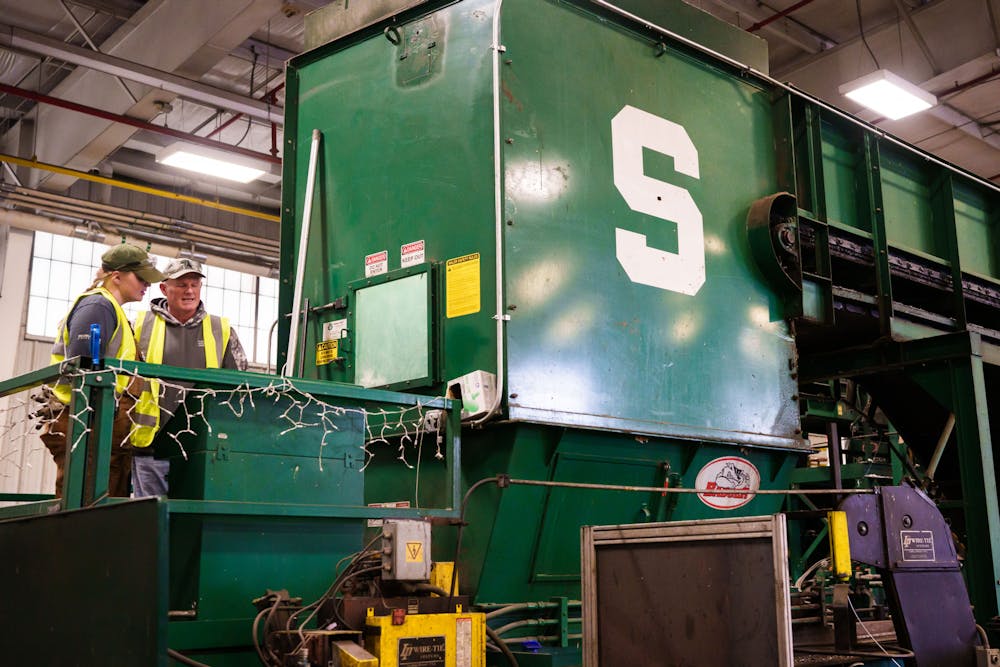 MSU Recycling Center workers operate a baler, which is used to compress recycled goods into singular bales, which will later be sold, photographed on April 3, 2023.