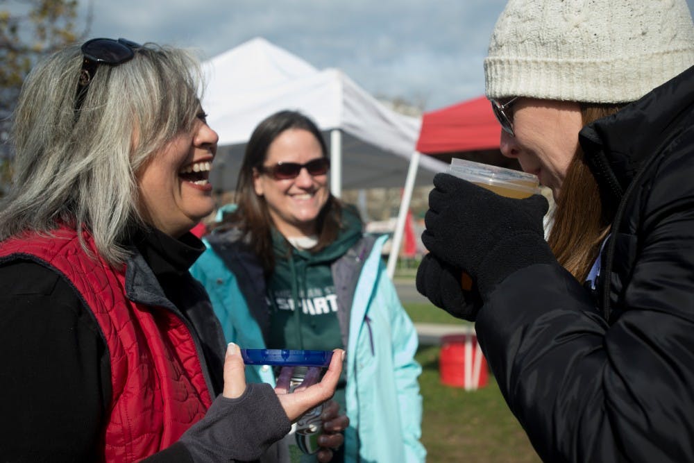 <p>Dublin, Ohio, resident Deb Papesh laughs as Dublin, Ohio resident Sara Miles tries a drink on Nov. 21, 2015 outside Ohio Stadium in Columbus, Ohio before the OSU/MSU football game.</p>