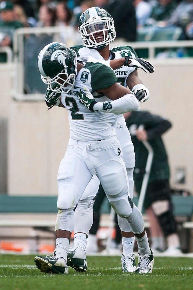 <p>Senior safety Kurtis Drummond celebrates with sophomore cornerback Darian Hicks, 2, during the Spring Green and White game on April 26, 2014, at Spartan Stadium. The White team, coached by defensive line coach Ron Burton, defeated the Green team, 20-13. Danyelle Morrow/The State News</p>