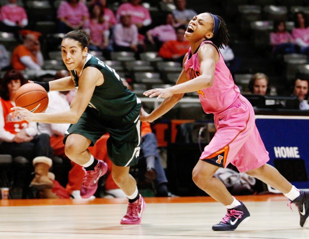 Senior guard Brittney Thomas drives the ball past Illinois guard Adrienne GodBold on Sunday afternoon at the Assembly Hall in Champaign, Ill. The Spartans defeated the Fighting Illini, 69-56, to clinch a share of the Big Ten Conference title. Daryl Quitalig/The Daily Illini