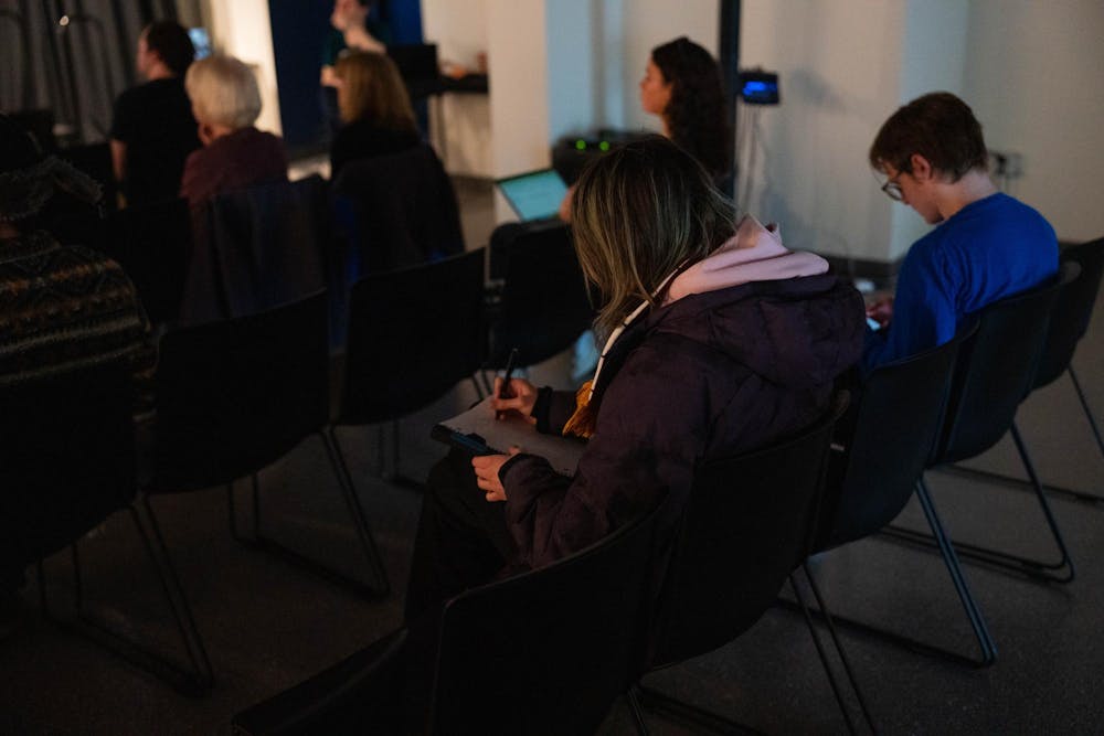 An attendee jotting down key ideas during the AI, Elections, and the Fight for Facts Event at the MSU Museum in East Lansing, on March 19 2026.