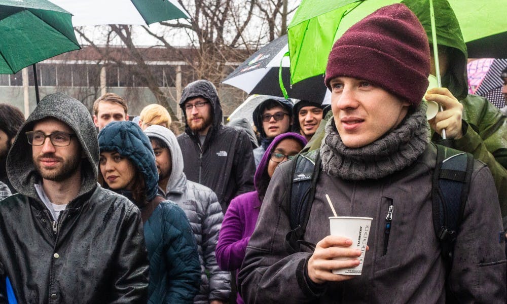Attendees brave the weather to listen to speakers at a teach-in rally held by the Graduate Employees Union at the Rock on Farm Lane on March 20, 2019.