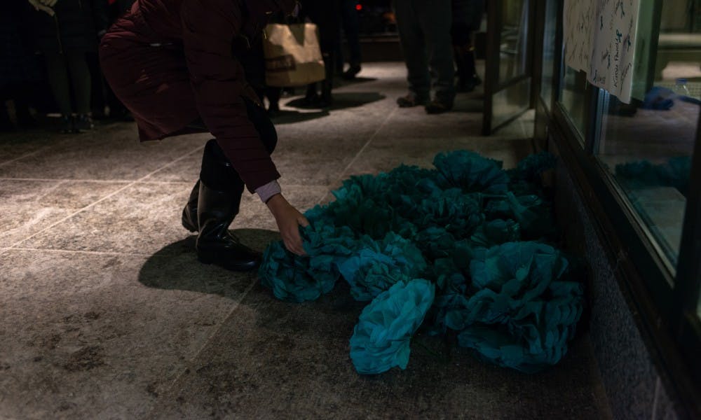 <p>Members of the audience ended the rally by laying teal paper flowers at the foot of a banner reading &quot;Courage&quot;  at the Hannah Administration Building on Jan. 24, 2019. The demonstration was held on the one-year anniversary of Larry Nassar being sentenced to 40 to 175 years in prison.</p>