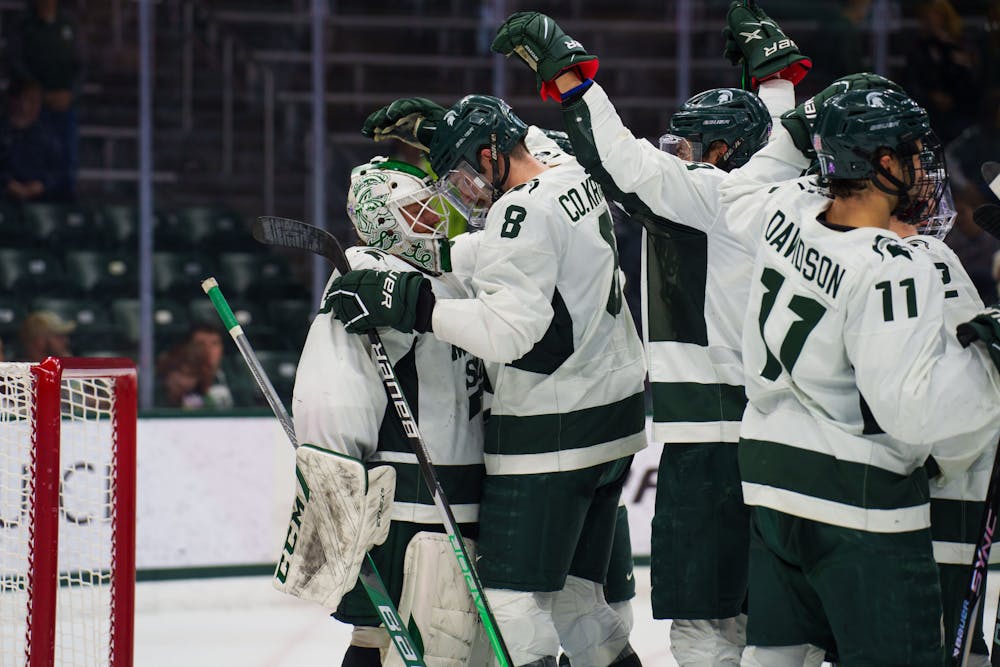 Graduate Student goalie Dylan St. Cyr (37) celebrates a win over Ohio State with his teammates. The Spartans defeated the Buckeyes 4-2 at Munn Ice Arena on Nov. 10, 2022.