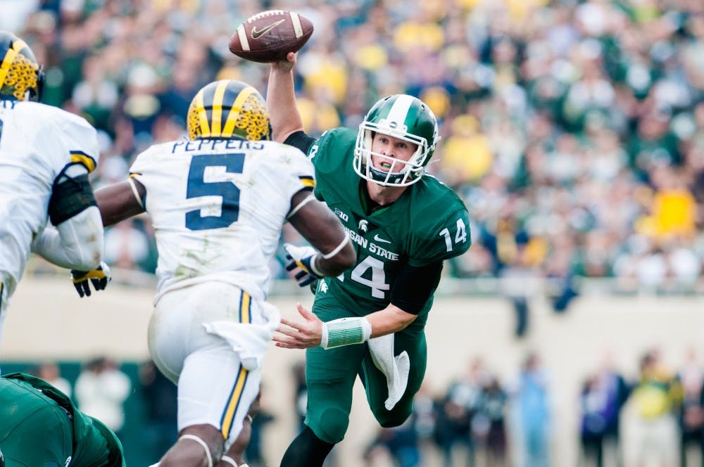 Freshman quarterback Brian Lewerke (14) stumbles while scrambling during the game against the University of Michigan on Oct. 29, 2016 at Spartan Stadium. The Spartans were defeated by the Wolverines, 32-23.