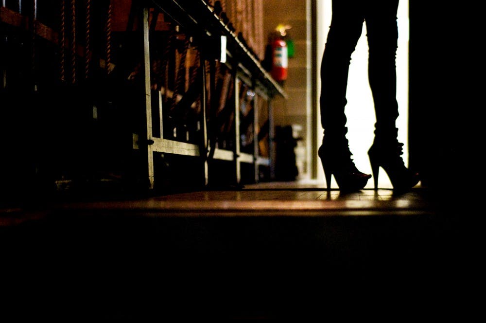 A model stands in heels before going out onto the runway for the ninth annual Alpha Phi Alpha Hair and Fashion Show Friday night at Wharton Center's Pasant Theatre. Local companies like Old Navy, DEB and DEFYE helped sponsor the show. Lauren Wood/The State News