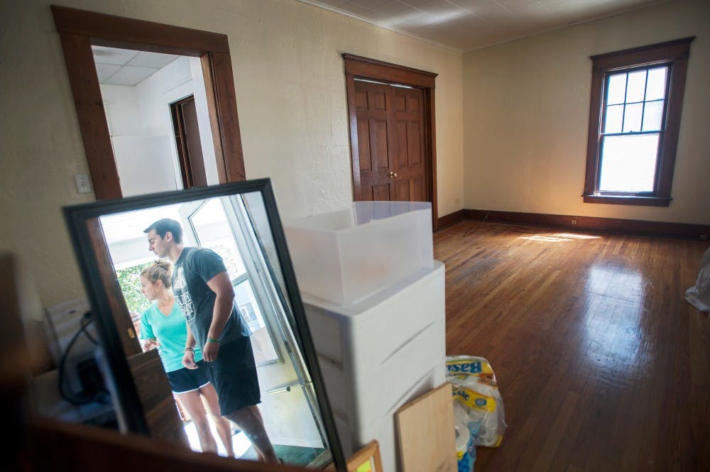 Recent advertising graduate Aaron Smith, of Lake Orion, Mich., stands with Shelby Charter Township, Mich. resident Alex Wolak near a mirror on the porch of a house on Bailey Street on Sunday, Aug. 5, 2012. After living in this house for a year, Smith and his friends are moving out as they graduate from college. Justin Wan/The State News