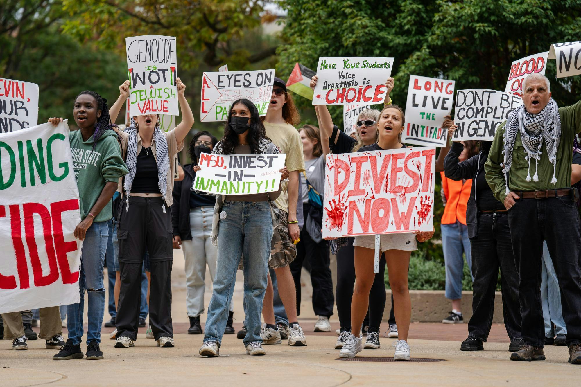 <p>Hurriya coalition protestors demand divestment from the university outside of President Guskiewicz's investiture at the Wharton Center on Sept. 29, 2024. The protesters were positioned facing the front of the building that looked into the investiture ceremony. Certain attendees wearing ceremonial regalia faced the protestors through the windows. The Hurriya Coalition is a collective of over 20 organizations fighting for freedom and justice for Palestine at MSU.</p>