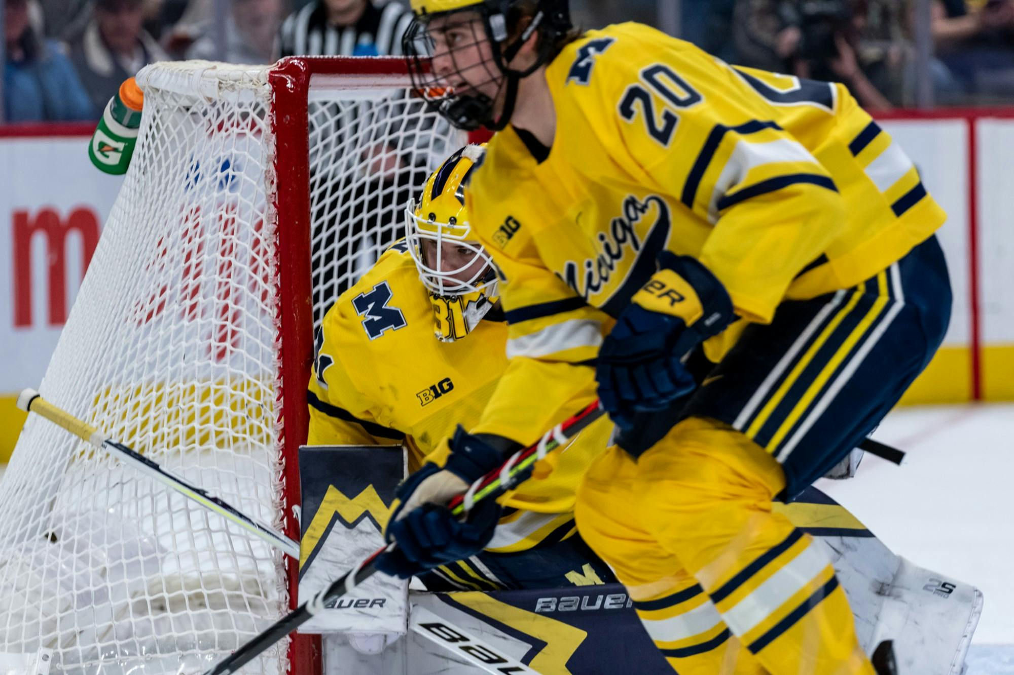 Michigan goaltender Strauss Mann (left) watches the puck in the corner. The Spartans fell to the Wolverines, 1-4, at Little Caesars Arena on February 17, 2020. 
