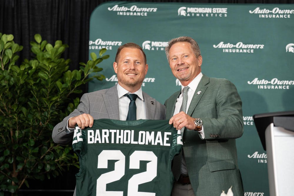 <p>President Kevin Guskiewicz welcomes Michigan State University's new vice president and athletic director, Dan Bartholomae, to the stage with a custom jersey at a press conference introducing him to the community at the Breslin Center in East Lansing, Mich., on Aug. 19, 2026.</p>