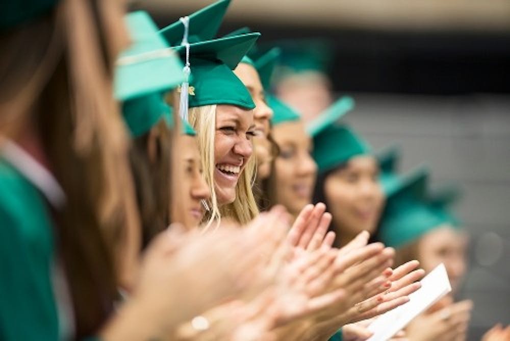 Education senior Jaclyn Botsford laughs during the playing of the "Michigan State Fight Song" during the Spring Convocation ceremony May 2, 2014, at Breslin Center. Graduating seniors were honored as a whole prior to individual college commencement ceremonies. Danyelle Morrow/The State News