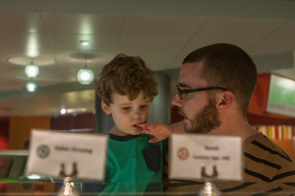 Assistant community director Dave Koch walks through the salad bar line with his son, Eddie, on Sept. 3, 2016 inside Brody Cafe. Koch's position provides a unique opportunity to experience campus life with his son. 