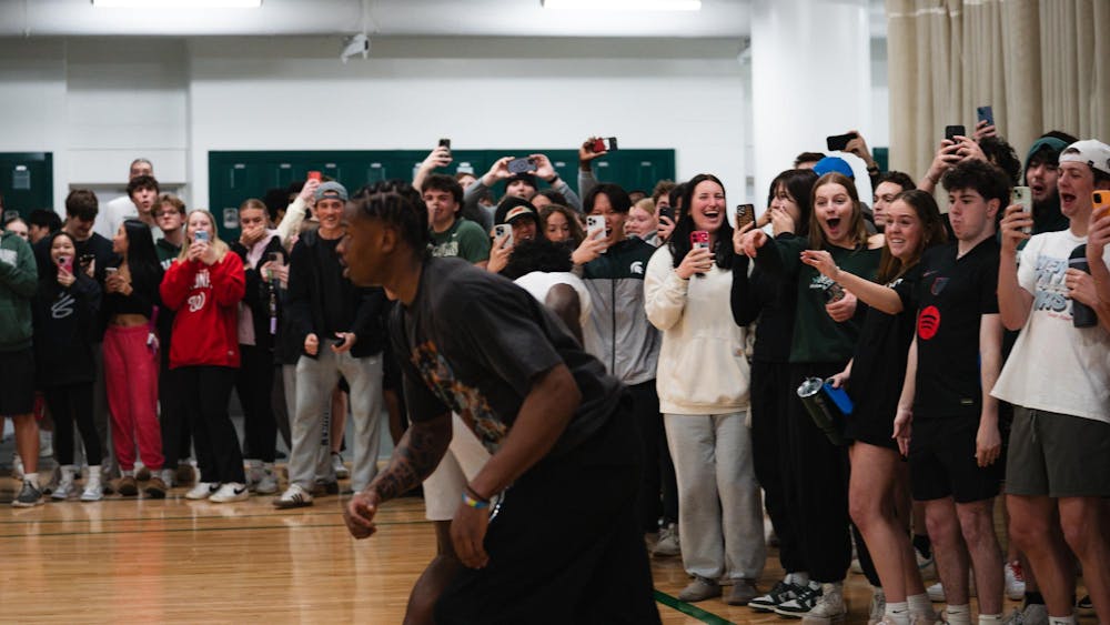 Michigan State students react to a dunk from sophomore forward Coen Carr at IM East on April 16, 2025. The men's basketball team played in pickup runs on campus for students to enjoy.