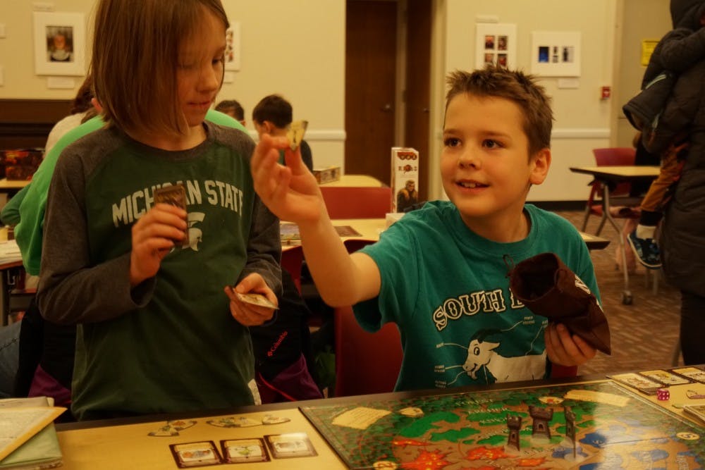 <p>Xan and Finney Clarkson play a board game during the East Lansing Public Library's first monthly board game event on Jan. 12, 2019.</p>