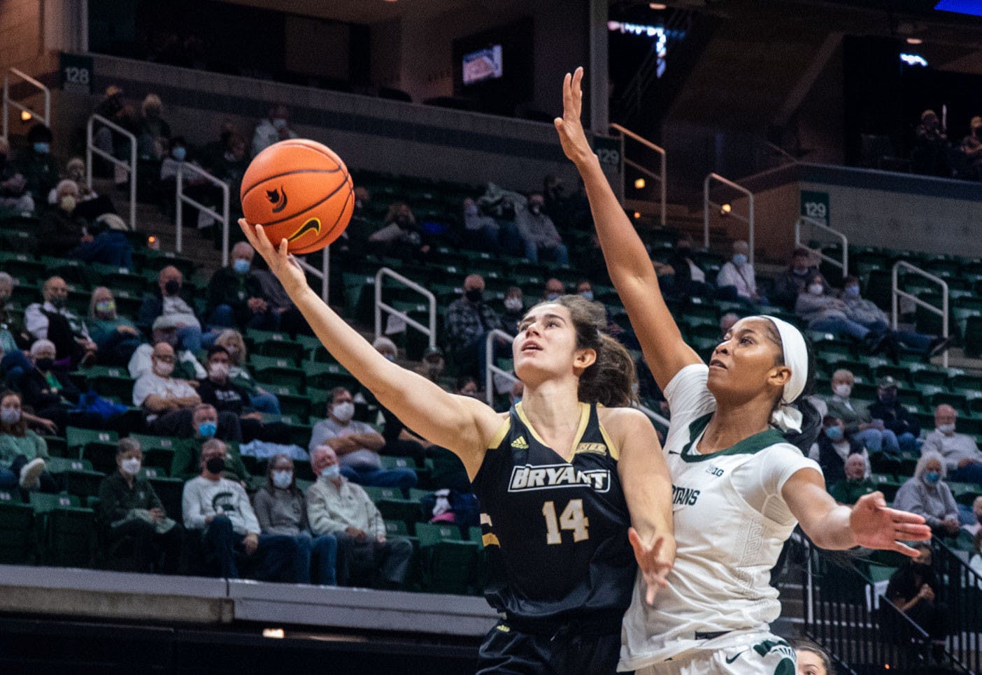 <p>Graduate student forward Alisia Smith (4) attempts to block a Bryant basket in the first quarter. The Spartans crushed the Bulldogs, 100-60, which led coach Suzy Merchant to her 300th win with Michigan State on Nov. 19, 2021.</p>