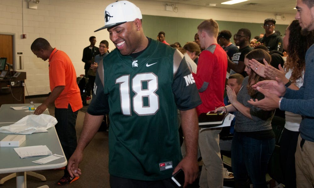 <p>MSU alumnus&nbsp;Eric Thomas walks off after introducing motivational speaker Derrick Williams, far left, on Oct. 6, 2015 in Conrad Hall. Thomas hosts a motivational series, which sometimes features guest speakers, that takes place on MSU's campus every Tuesday night. Thomas was a mentor to Williams for the past ten years.</p>