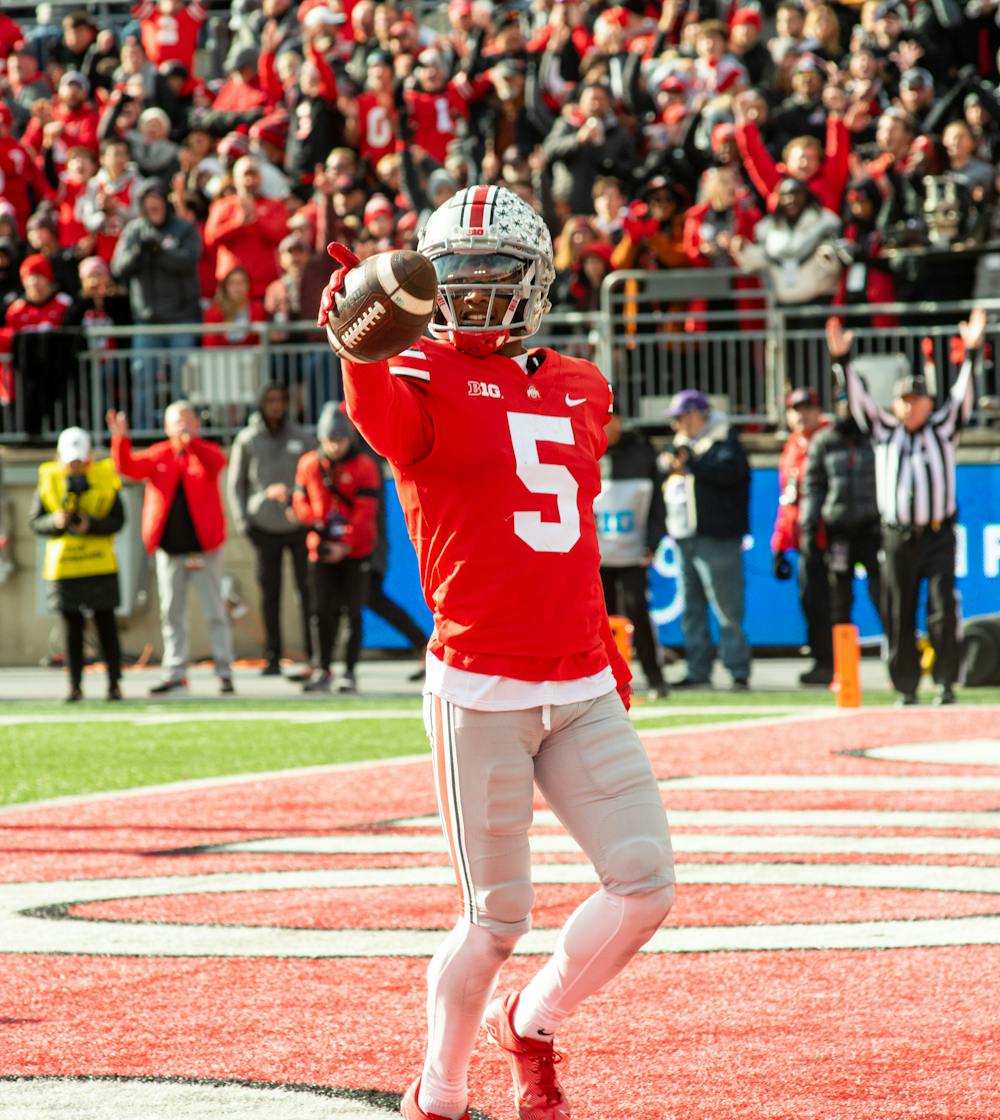 <p>Ohio State wide receiver Garrett Wilson (5) shows off the ball after scoring a touchdown during Michigan State&#x27;s loss to Ohio State on Nov. 20, 2021.</p>