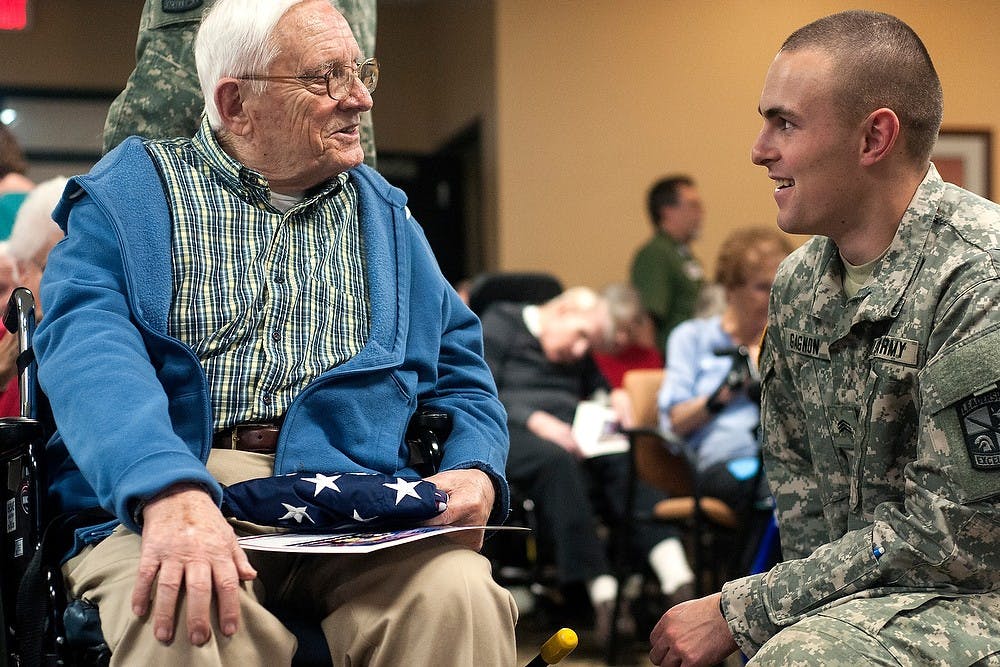 <p>East Lansing resident Robert F. Birdsall and applied engineering sciences sophomore Collin Gagnon talk during a Veteran's Day ceremony Nov. 11, 2014, at Burcham Hills Retirement Community. Birdsall, a WWII veteran, was honored with a retired flag from the MSU ROTC. Jessalyn Tamez/The State News</p>