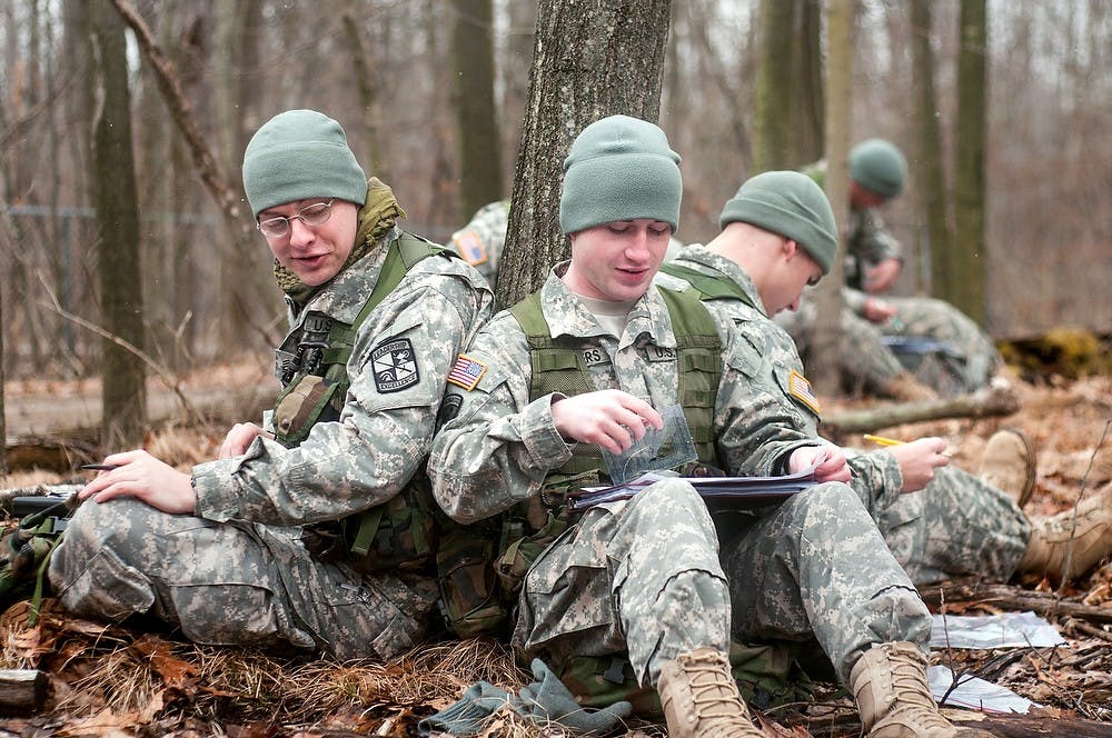 Engineering junior Andrew Cross, left, and political science junior Kyle Kueppers, right, talk during a plotting session at a wooded area owned by the Army ROTC on Dobie Road in Okemos on Tuesday, March 12, 2013. The cadets had ten minutes to plot coordinates on maps in order to find the points during a navigational skills test. Danyelle Morrow/The State News