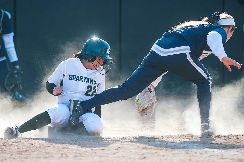 	<p>Junior outfielder Dana Briggs scores a run by the home plate as she runs into a Penn State player  April 3, 2013, at Secchia Stadium at Old College Field. The Spartans defeated the Nittany Lions in the second game of the doubleheader, 7-1. Justin Wan/The State News</p>