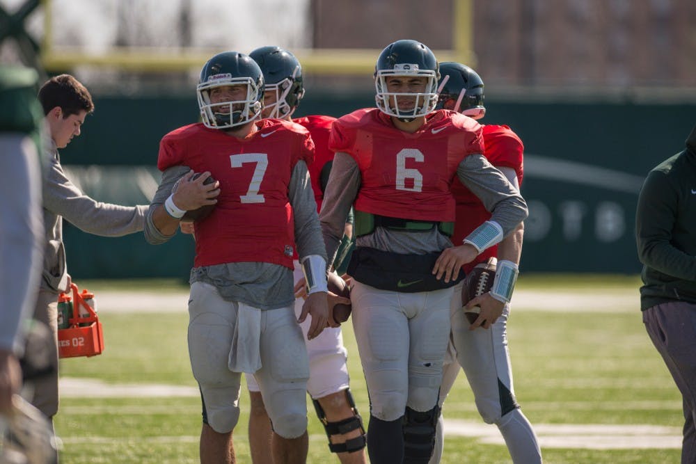 Senior quarterback Tyler O'Connor, 7, and junior quarterback Damion Terry, 6, rest during spring practice on April 5, 2016 at the practice fields behind the Duffy Daugherty Football Building.