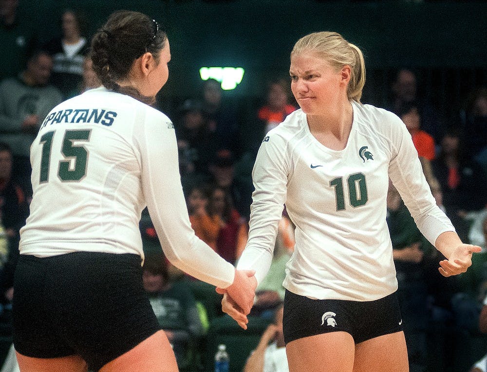 Junior middle blocker Kelsey Kuipers (10) reassures junior outside hitter Lauren Wicinski (15) before the start of a game against Illinois on Saturday Oct. 13, 2012 at Jenison Field House. Katie Stiefel/ State News