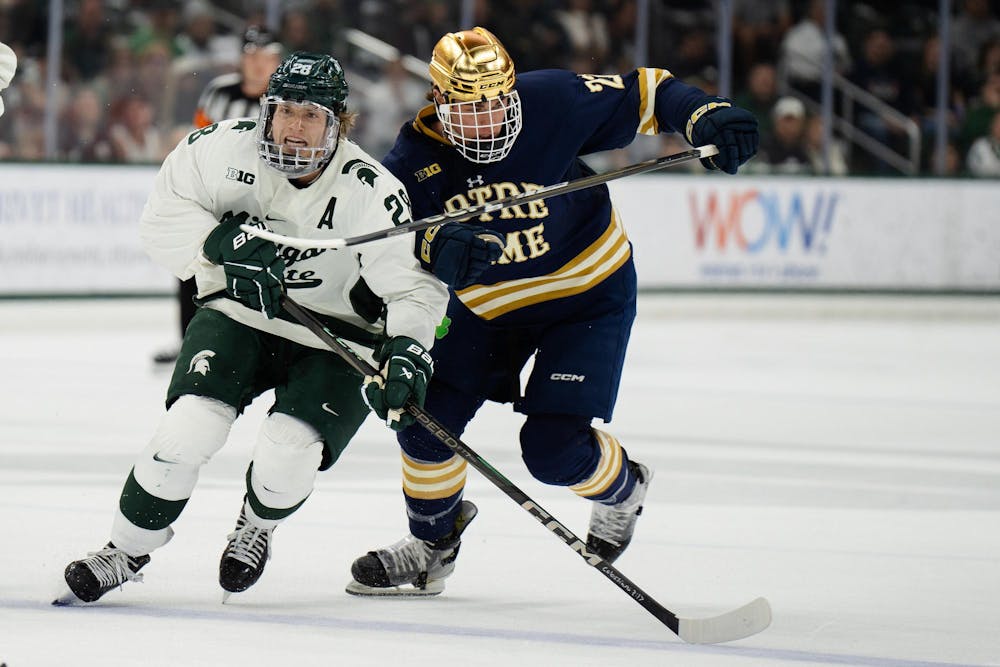 <p>Michigan State junior forward Karsen Dorwart (28) races Notre Dame graduate forward Blake Biondi (27) to the puck at Munn Ice Arena on March 15, 2025. The Spartans took a 1-0 victory against the Fighting Irish, advancing to the Big Ten Championship.</p>