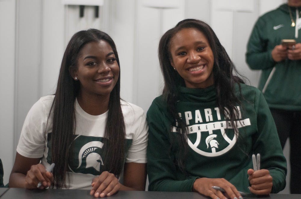 Red shirt senior guard Branndais Agee, left, and freshman forward Sidney Cooks sign autographs during Michigan State Madness on Oct. 20, 2017 at Breslin Center.