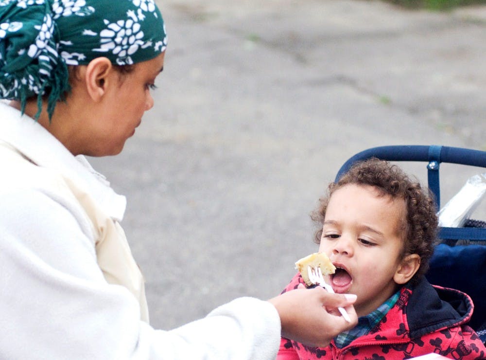 	<p>Lansing resident Tashmich Torok feeds her son Levi, 2, chocolate chip pancakes Sunday morning at Patriarche Park, 1100 Alton Road, during the annual Pancakes in the Park. Hosted by the East Lansing Rotary Club, the yearly breakfast ritual invited members of the Greater Lansing community to enjoy a fully cooked breakfast as well as vote for the best poster in the Remember the Park campaign.</p>