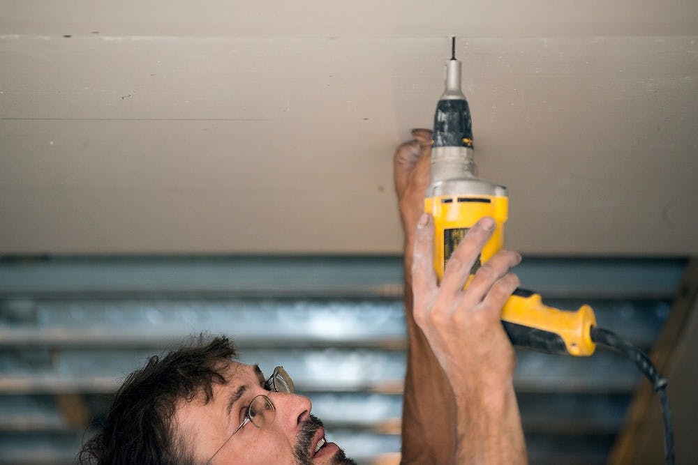 <p>Brant, Mich., resident Alex Plowman does construction work July 9, 2014, on the Midtown Apartments, 3433 E. Michigan Ave. The project, that broke ground October 2013, is set to be completed in early August. Danyelle Morrow/The State News</p>