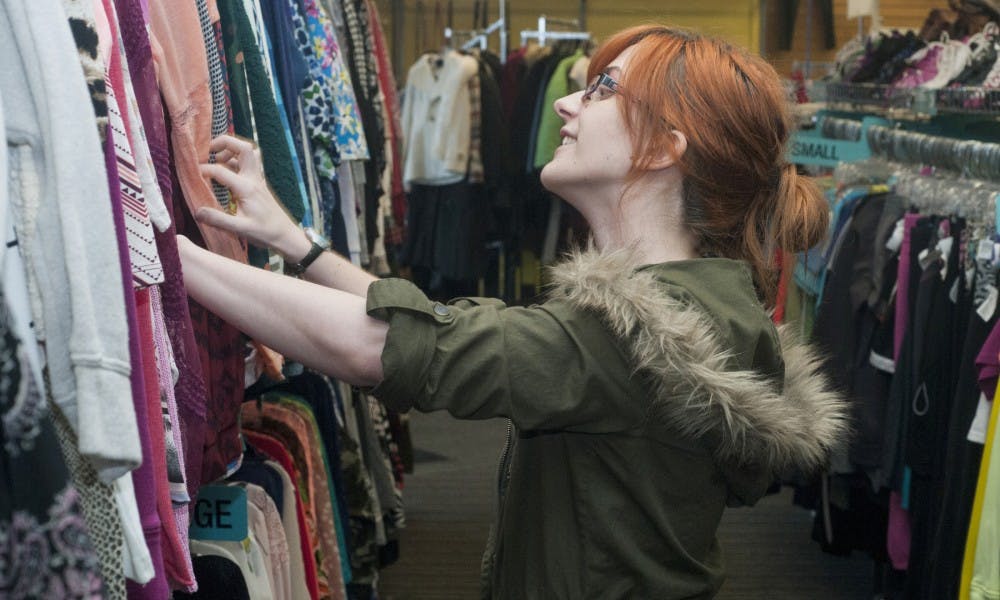 Lansing Community College freshman Megan Scott searches through clothes on Jan. 9, 2016 at Plato's Closet on 2843 East Grand River Ave. Scott recently received acceptance to an internship and was shopping for business clothes. 