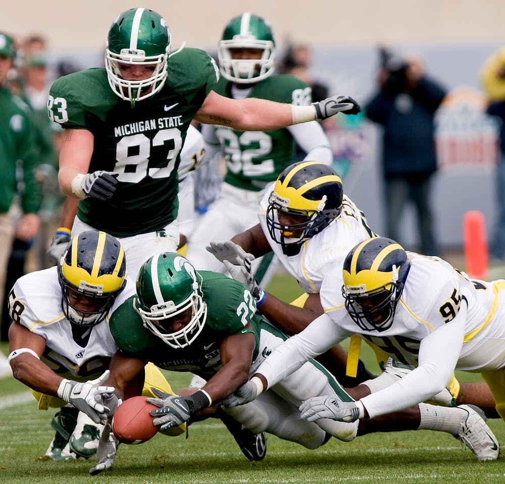 <p>Freshman running back Larry Caper fights for posession of the ball with several University of Michigan players after he fumbled it on Oct. 3, 2009, at Spartan Stadium. The Spartans defeated the Wolverines, 26-20, in overtime. Josh Radtke/The State News</p>