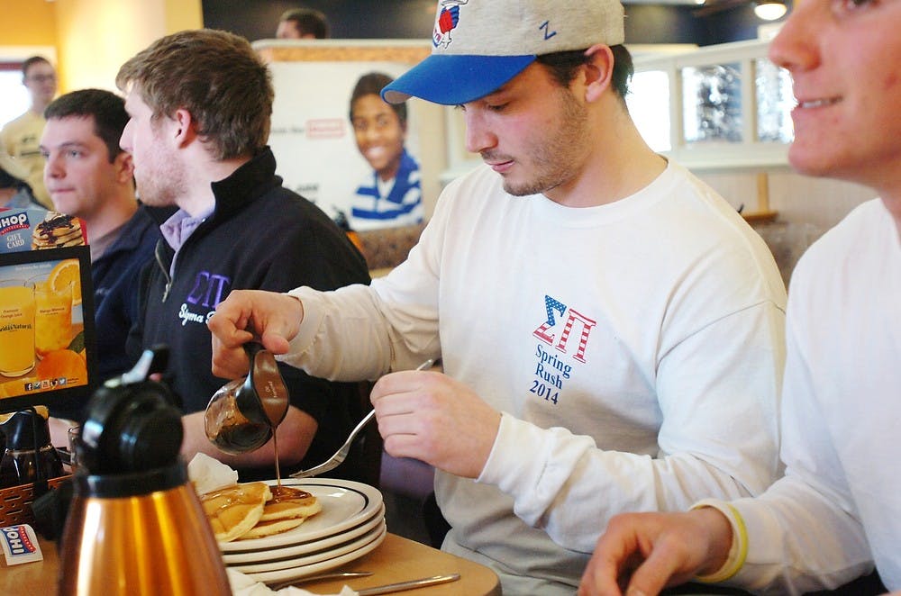 <p>Mathematics sophomore Jeffrey Cortese pours syrup onto his pancakes during a pancake eating contest March 24, 2014, at IHOP, 2771 E. Grand River Ave. The contest was hosted by Sigma Pi and MSU Up 'til Dawn and the proceeds went to St. Jude Children's Research Hospital. Emily Jenks/The State News</p>