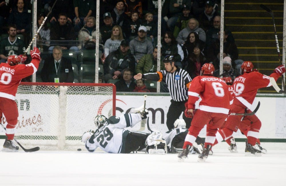 Junior goaltender Drew Palmisano reaches for a puck that slipped by him, but is too late after Miami (Ohio) scores its second goal of the game Saturday at Munn Ice Arena. Palmisano let a four goals in and MSU lost to the RedHawks, 4-0. Kat Petersen/The State News