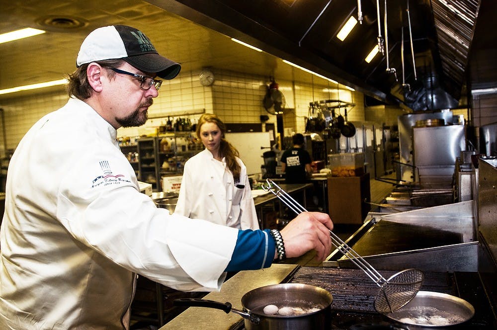 <p>Chef Kurt Kwiatkowski places eggs into boiling water March 10, 2014, at the test kitchen in McDonel Hall. Kwiatkowski was testing a new method of egg poaching in order to get a runny yolk result and experimented with boiling the eggs at at various time increments. Erin Hampton/The State News</p>
