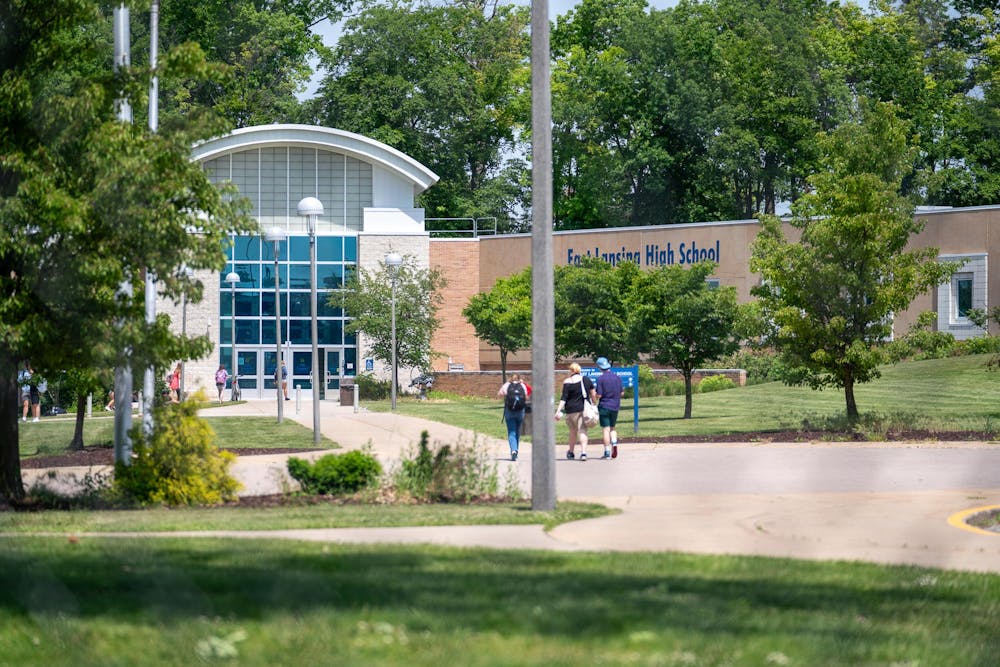 Students and faculty walk into the front doors of East Lansing High School on May 24, 2024.